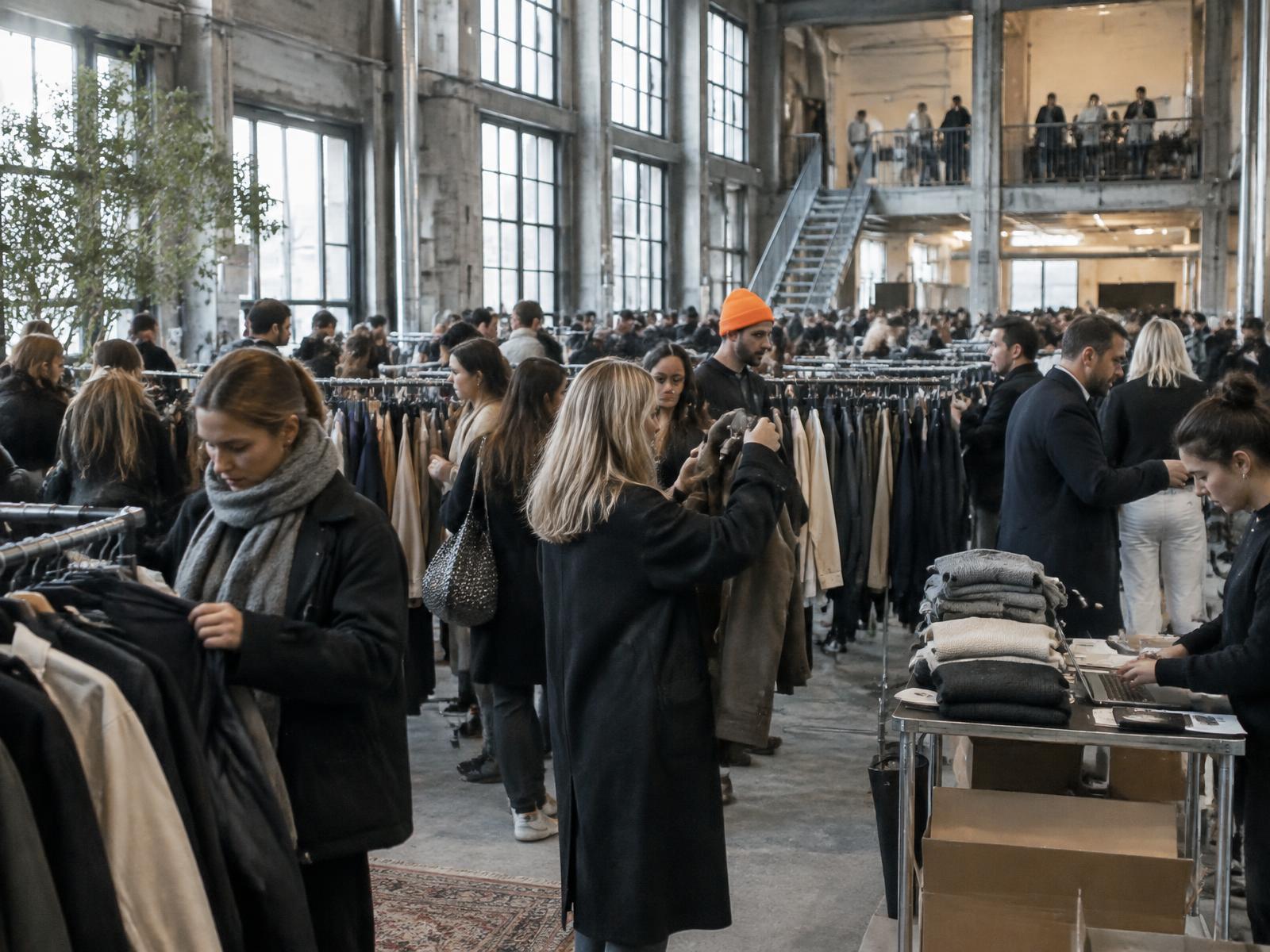 Et aktivt archive sale med gæster, team og fyldte tøjstativer